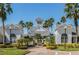 Elegant clubhouse featuring manicured landscaping, classic architecture, and beautiful palm trees at 130 Southern Pecan Cir # 204, Winter Garden, FL 34787