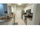 Galley kitchen with stainless steel appliances, granite countertops, and white cabinetry at 130 Southern Pecan Cir # 204, Winter Garden, FL 34787