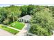Aerial view of a home with a well-manicured lawn, driveway, and mature trees at 1311 Rain Forest Ln, Minneola, FL 34715