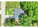 Birds eye view of a lovely home with lush green trees surrounding the property and street at 1311 Rain Forest Ln, Minneola, FL 34715