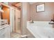 Bright bathroom featuring a large tub, glass shower, and well-lit vanity at 1311 Rain Forest Ln, Minneola, FL 34715
