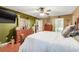 Bright bedroom with olive green and tan walls, ceiling fan, and wood furniture at 1311 Rain Forest Ln, Minneola, FL 34715