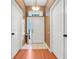 Inviting entrance hallway with tiled floor transitioning to hardwood, bathed in natural light from the front door window at 1311 Rain Forest Ln, Minneola, FL 34715