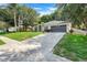 Beautifully landscaped home featuring a long driveway and mature trees at 1311 Rain Forest Ln, Minneola, FL 34715