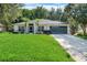 Charming single-story home featuring a lush green lawn and a two-car garage at 1311 Rain Forest Ln, Minneola, FL 34715