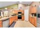 Well-lit kitchen with modern appliances including a stainless steel dishwasher, oven, and microwave, complemented by sleek cabinetry at 1311 Rain Forest Ln, Minneola, FL 34715