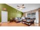 Comfortable living room with a large leather sectional, hardwood floors, a ceiling fan, and plenty of natural light at 1311 Rain Forest Ln, Minneola, FL 34715