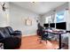 Office space features an ergonomic chair and adjustable desk setup with hardwood floors and a comfortable leather couch at 1311 Rain Forest Ln, Minneola, FL 34715