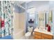 Well-lit bathroom featuring a shower-tub combo, vanity, and fresh blue accents at 13165 Se 93Rd Cir, Summerfield, FL 34491