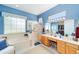 Large bathroom with double sinks, a walk-in shower, a soaking tub, and ample natural light at 13165 Se 93Rd Cir, Summerfield, FL 34491