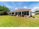 Charming home with a well-maintained lawn and sunroom featuring multiple windows for natural light at 13165 Se 93Rd Cir, Summerfield, FL 34491