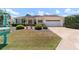 Inviting single-story home featuring a well-kept lawn, mature shrubbery, and a convenient attached garage at 13165 Se 93Rd Cir, Summerfield, FL 34491