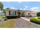 Charming single-Gathering home featuring a manicured lawn, mature landscaping, and an attached two-car garage at 13165 Se 93Rd Cir, Summerfield, FL 34491