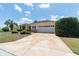 Attractive single-story home boasting a patterned driveway, manicured landscaping, and an attached two-car garage at 13165 Se 93Rd Cir, Summerfield, FL 34491