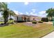 A charming single-story home showcasing a well-manicured lawn, lush landscaping, and an attached garage at 13165 Se 93Rd Cir, Summerfield, FL 34491