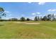 An expanse of the golf course green is captured in the distance with a sand trap taking center stage at 13165 Se 93Rd Cir, Summerfield, FL 34491