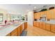 Well-lit kitchen with wood cabinetry and a view to the living area at 13165 Se 93Rd Cir, Summerfield, FL 34491