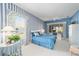 Comfortable main bedroom featuring blue and white decor, plush carpeting and bright natural light at 13165 Se 93Rd Cir, Summerfield, FL 34491