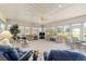 Spacious sunroom filled with light featuring diverse seating arrangements and a ceiling fan at 13165 Se 93Rd Cir, Summerfield, FL 34491