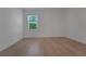 A light-filled bedroom features light-colored wood flooring, crisp white walls, and a window with natural views at 14249 Crest Palm Ave, Windermere, FL 34786