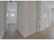 Bright hallway featuring wood floors and white walls, showcasing access to various rooms in the home at 14249 Crest Palm Ave, Windermere, FL 34786