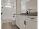 Modern bathroom featuring tiled shower and floors, white cabinets and dark fixtures at 14261 Crest Palm Ave, Windermere, FL 34786