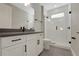 This bathroom features a vanity with dark hardware and a walk-in shower with bright white tile at 14261 Crest Palm Ave, Windermere, FL 34786