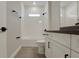 Modern bathroom featuring tiled shower and floors, white cabinets and dark fixtures at 14261 Crest Palm Ave, Windermere, FL 34786