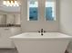 Elegant freestanding tub with modern faucet and cabinet in a bright, modern bathroom at 14261 Crest Palm Ave, Windermere, FL 34786