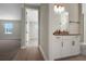 Hallway view of a modern bathroom with a white vanity and tile shower adjacent to carpeted living space at 14261 Crest Palm Ave, Windermere, FL 34786