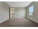 Bright bedroom with a neutral color scheme, soft carpet, and an open bathroom door at 14261 Crest Palm Ave, Windermere, FL 34786