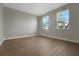 Light-filled room with wood-look flooring and dual windows framing palms at 14261 Crest Palm Ave, Windermere, FL 34786