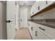 This laundry room showcases a stylish design with sleek white cabinets, dark hardware, and a sink at 14261 Crest Palm Ave, Windermere, FL 34786