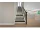 View of the staircase with black iron railing leading to the open-concept kitchen at 14261 Crest Palm Ave, Windermere, FL 34786