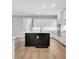 Bright, open kitchen features a black island, stainless appliances, and sleek white cabinetry at 14285 Crest Palm Ave, Windermere, FL 34786