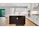 Bright, open kitchen features a black island, stainless appliances, and sleek white cabinetry at 14285 Crest Palm Ave, Windermere, FL 34786