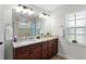 Bathroom features a double sink with granite countertops and a walk-in shower at 15022 Se 94Th Ct, Summerfield, FL 34491