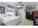 This bedroom features a bed, ceiling fan and two safes at 15022 Se 94Th Ct, Summerfield, FL 34491