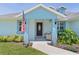 Inviting front entrance of the home with a charming front porch, cozy seating, and well-maintained landscaping at 15022 Se 94Th Ct, Summerfield, FL 34491