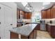 Well-equipped kitchen with stainless appliances, granite countertops, tile backsplash, and a functional center island at 15022 Se 94Th Ct, Summerfield, FL 34491