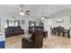 Spacious living room featuring comfortable leather seating, high ceilings, tile floors, and plenty of natural light at 15022 Se 94Th Ct, Summerfield, FL 34491