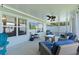 The covered patio boasts a ceiling fan, cozy furniture, and scenic views at 15022 Se 94Th Ct, Summerfield, FL 34491