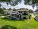 A spacious backyard features a screened-in pool, a lush green lawn, an outdoor living area, and an upper balcony at 16951 Florence View Dr, Montverde, FL 34756
