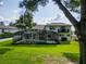 A large backyard features a screened-in pool, lush green lawn, outdoor living area, and a second story balcony at 16951 Florence View Dr, Montverde, FL 34756