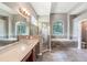 Bright primary bathroom featuring double sink vanity, soaking tub, and glass enclosed shower at 16951 Florence View Dr, Montverde, FL 34756