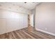 Spacious room with decorative wall paneling, light-toned wood-look flooring, and doorway to the staircase at 16951 Florence View Dr, Montverde, FL 34756