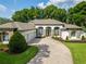 Beautiful home featuring stone accents, a paved driveway, manicured landscaping and a white exterior at 16951 Florence View Dr, Montverde, FL 34756