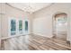 Cozy living room with high ceilings, luxury vinyl flooring, sofa, and sliding glass doors to the lanai at 16951 Florence View Dr, Montverde, FL 34756