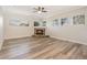 Bright living room featuring a stone fireplace, large windows, and hardwood flooring at 16951 Florence View Dr, Montverde, FL 34756