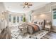 Staged main bedroom suite with hardwood flooring and views of the backyard and lanai at 16951 Florence View Dr, Montverde, FL 34756